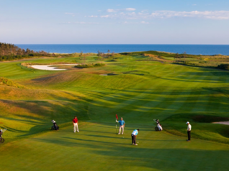 Golfers on a course overlooking the ocean