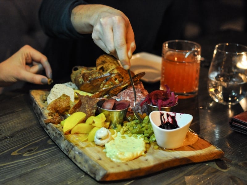 Close up of  charcuterie board and hands reaching in 