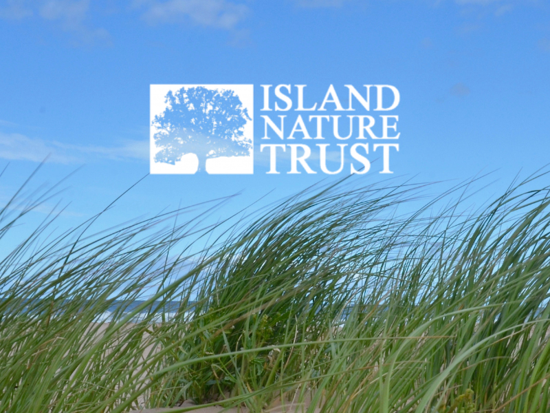 Logo of Island Nature Trust in front of image of dunes at PEI beach