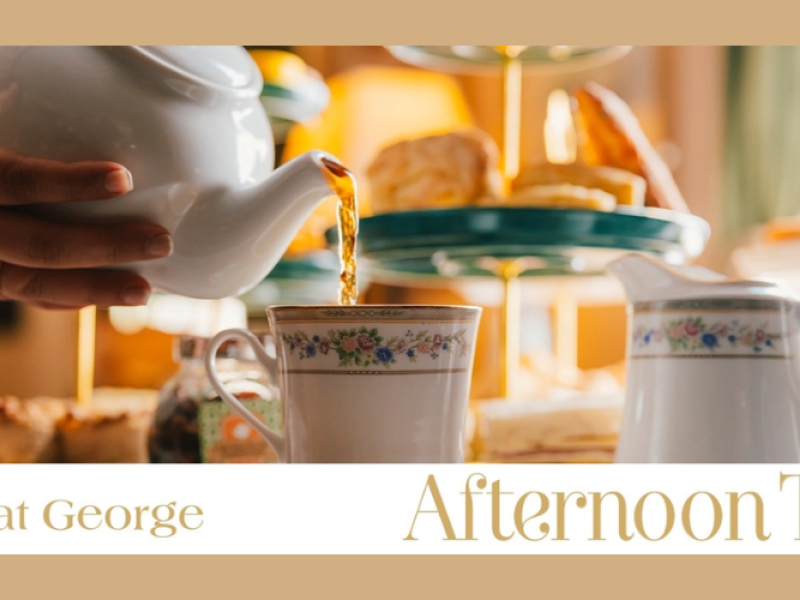 View of tea being poured from tea pot into tea cups