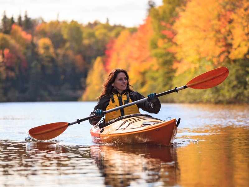Person in kayak on river in fall