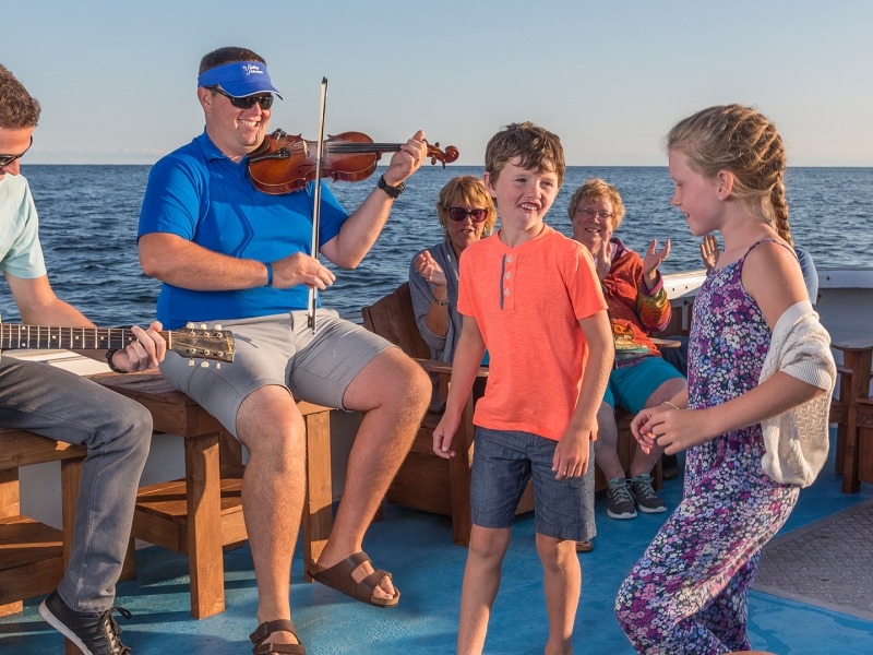 Fiddling Fisherman, children dancing, boat, ocean