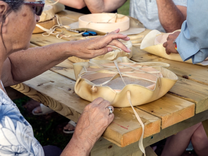 A woman working to assembe a Mi'kmaq drum