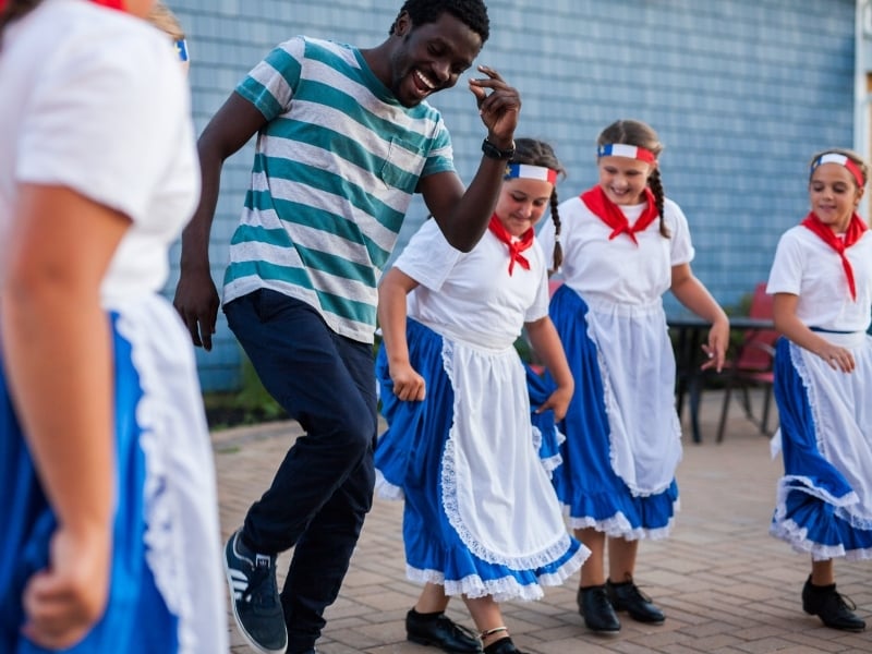 Visitor joins in with female Acadian dancers