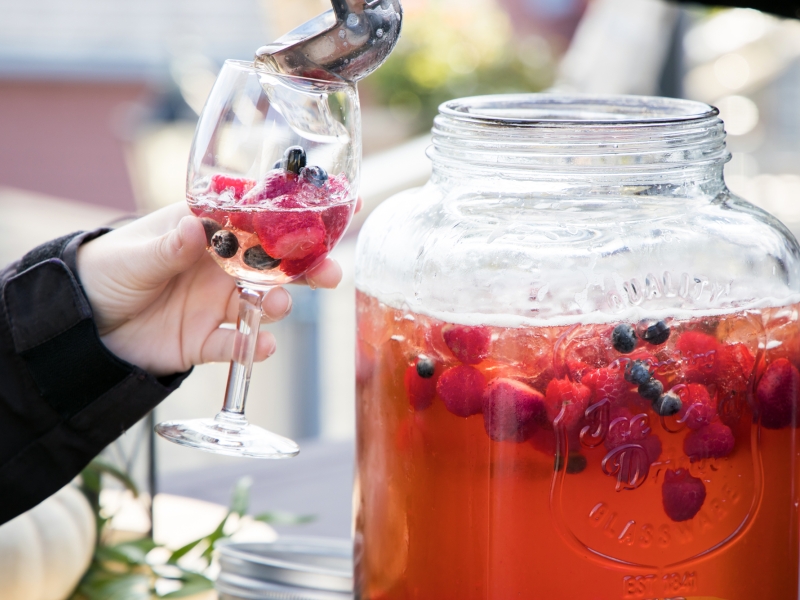 Person filling a wine glass with punch