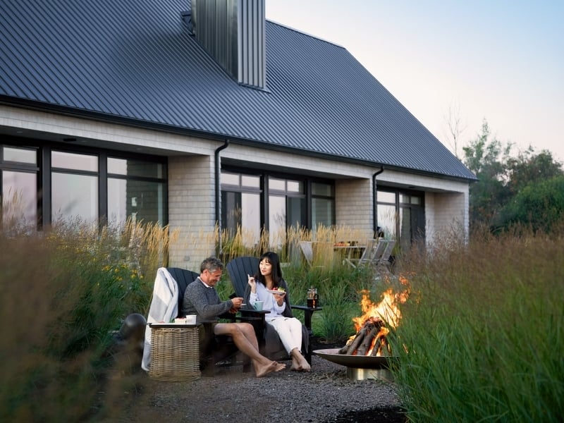 Two people have dessert by outdoor fire pit at luxurious PEI vacation home