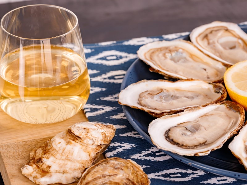 Plated oysters on the half shell with glass of wine