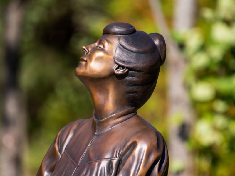 Close up of bronze statue of L.M. Montgomery at Montgomery Park in summer