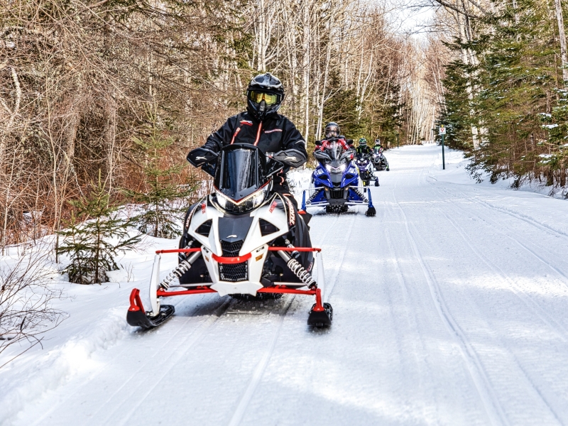 Convoy of snowmobiles on snow-covered Confederation Trail