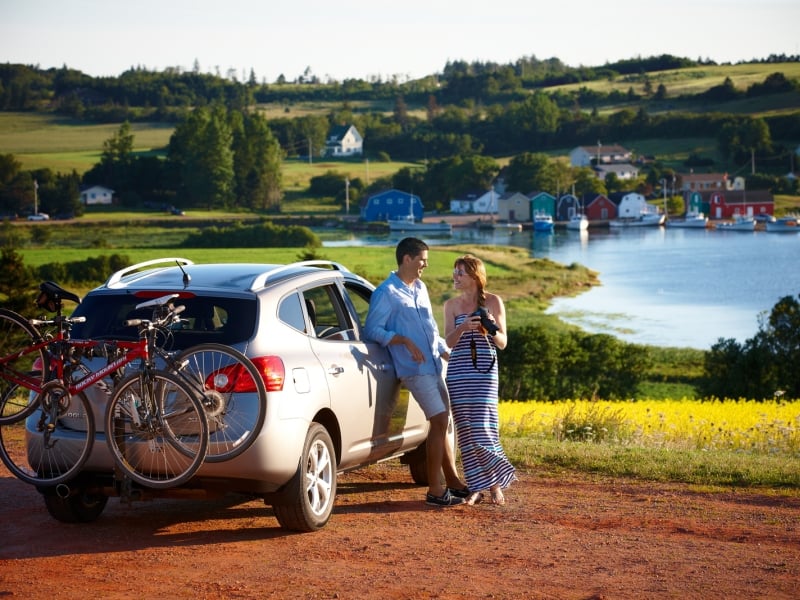Couple enjoy scenery at French River lookout, car with bike rack