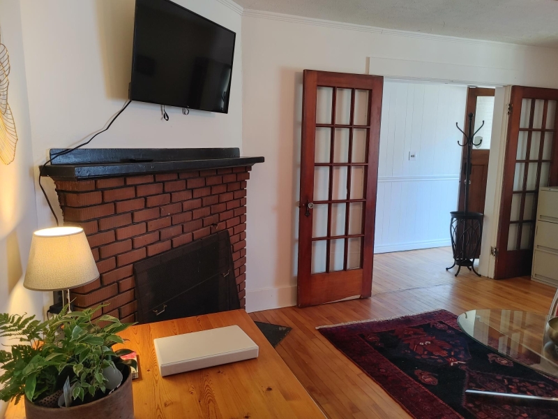photo looking at the living room. Fireplace and wood floors with french doors