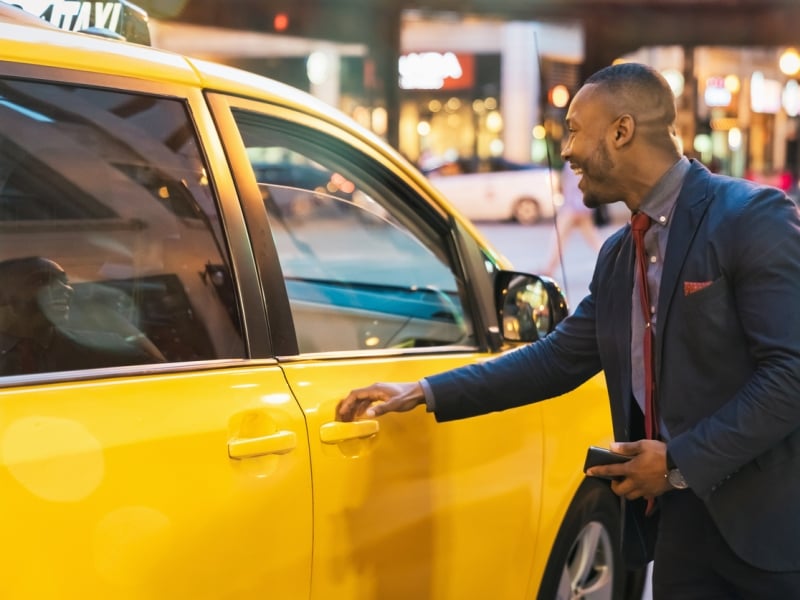 Person in business attire gets ready to get in a taxi