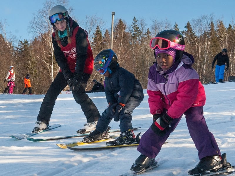 Ski instructor with young children on the hill