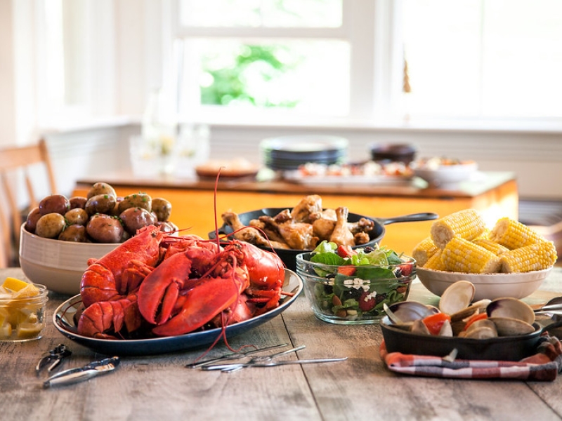 Table of fresh PEI Lobster, quahogs, salad, potatoes, corn and chicken