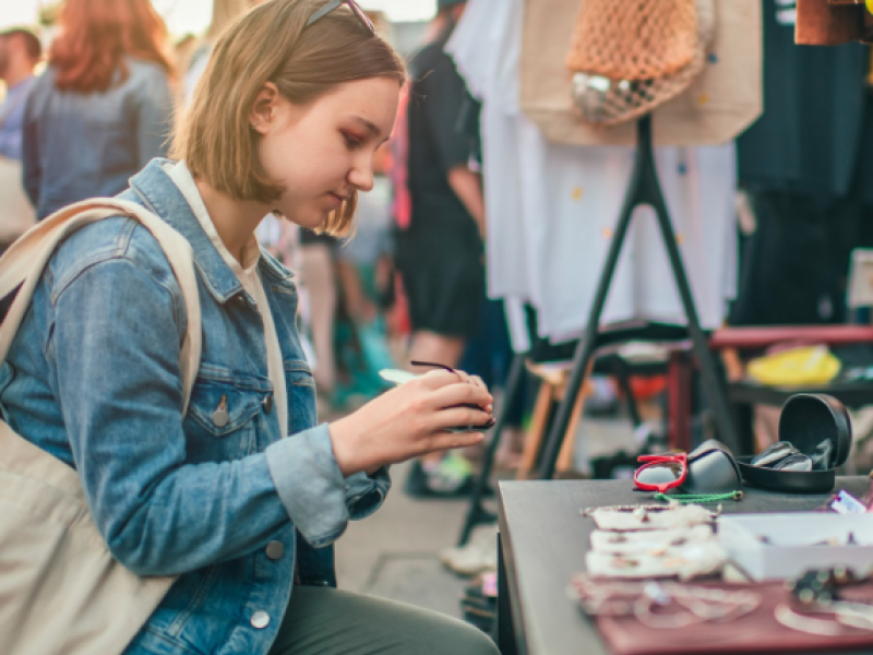 iStock image of young woman looking over items at yard sale