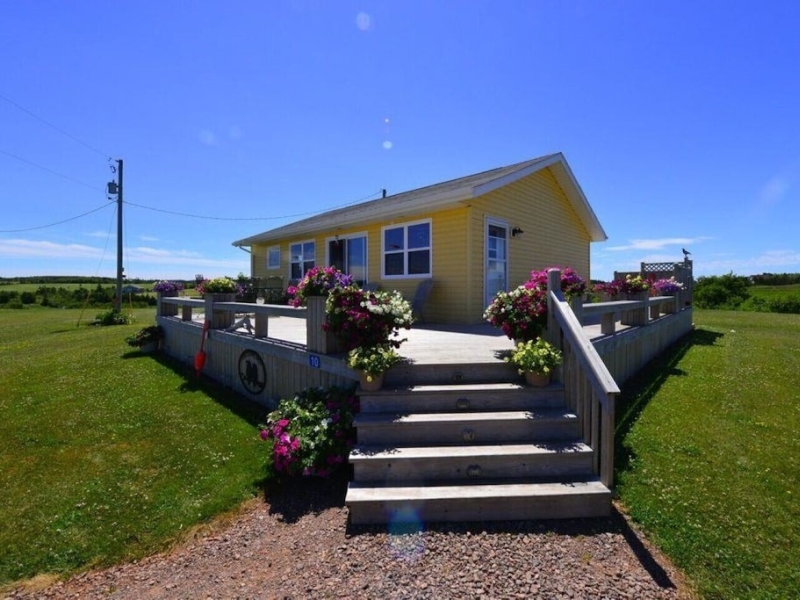Small yellow cottage with lovely wrap around deck and outdoor hot tub