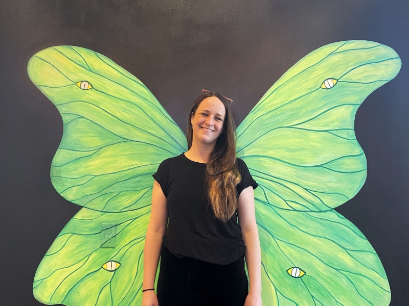 Artist Ashley Anne Clark stands in front of her mural at Founders Food Hall in Charlottetown