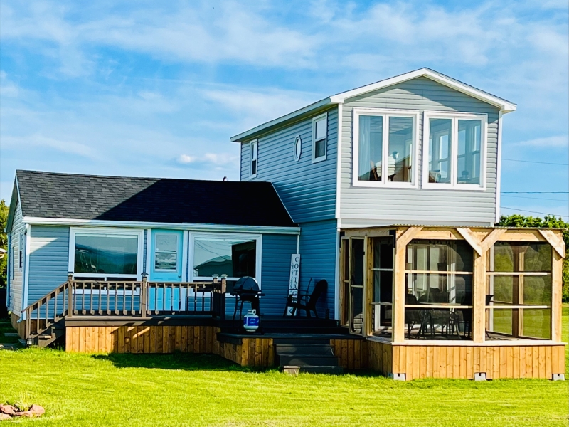Exterior photo of the Beach Haven Seashell Retreat cottage, with screened in deck area