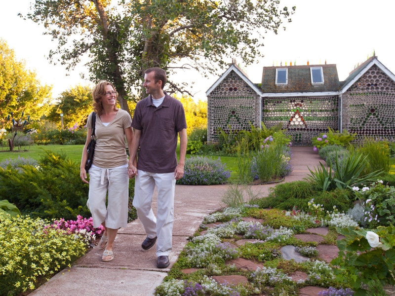 Couple walking through gardens at the Bottle Houses