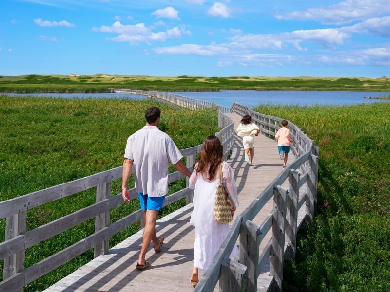 Family walks on boardwalk at Greenwich, PEI National Park