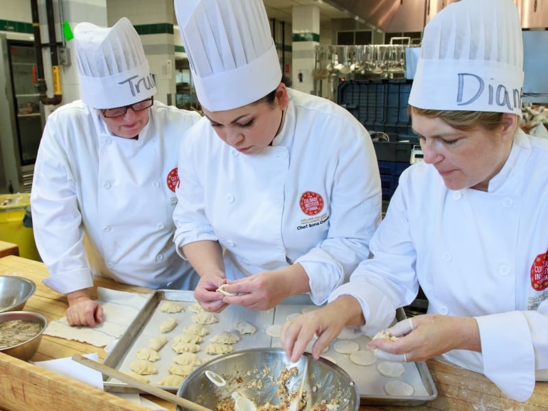 Chef ILona Daniel instructs two culinary bootcamp participants 