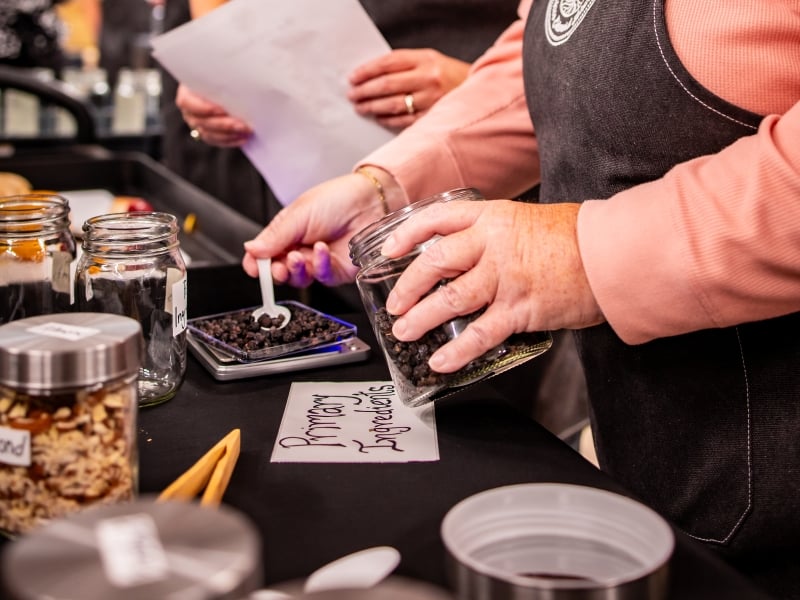 Two women preparing recipe in Distiller for a Day experience
