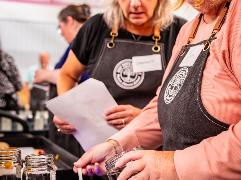 Two women preparing recipe in Distiller for a Day experience