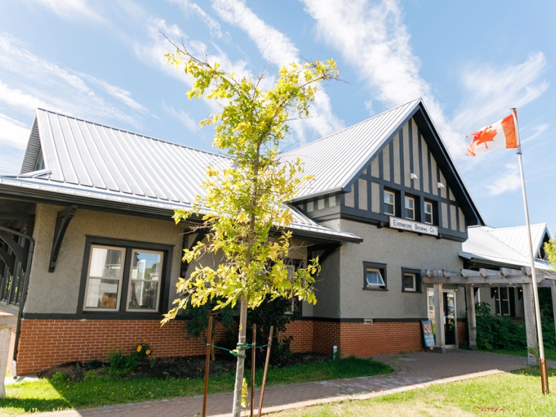 outside view , large grey building with tree in front of the building at Evermore brewing Company