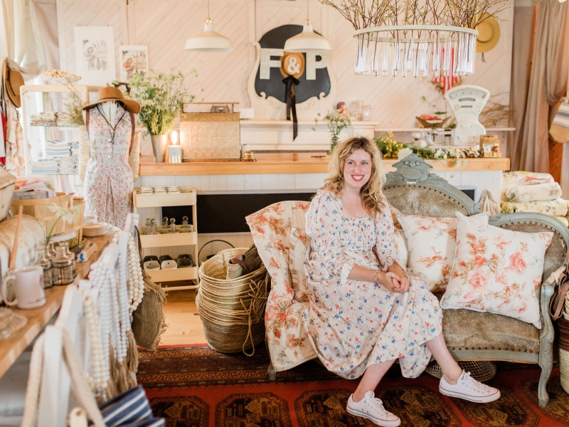 Indoor image of shop with owner, beautiful linens and decor