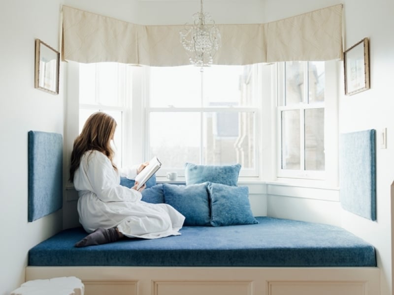 Woman reading from windown seat overlooking historic downtown Charlottetown