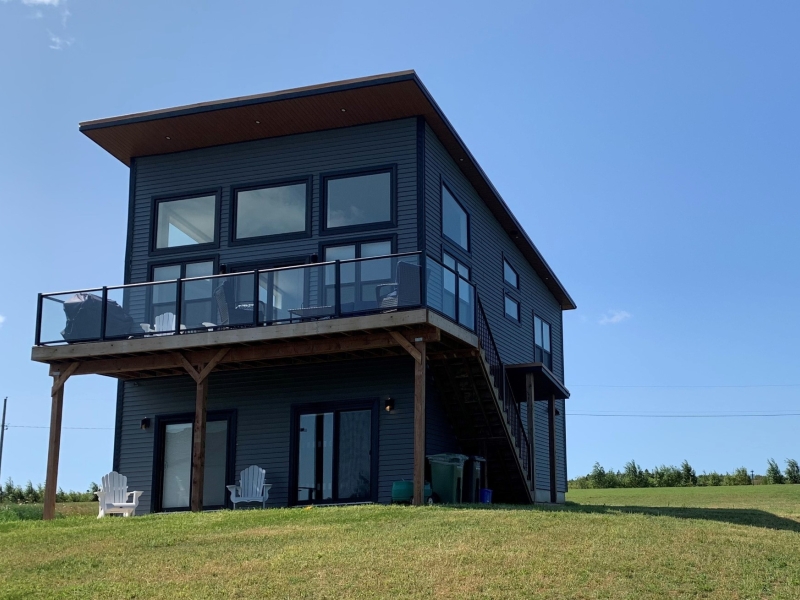 outside photo of a two story blue cottage with deck on second floor