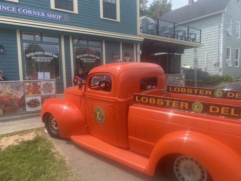 Red antique delivery truck outside of Water Prince Corner Shop