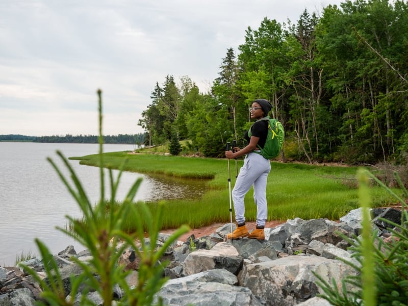 An Island Walk hiker at a waterview lookout in Little Harbour, Prince Edward Island
