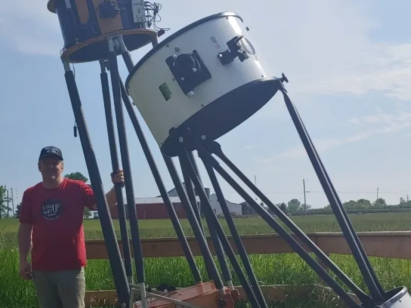 Wesley Stewart stands beside his giant telescope