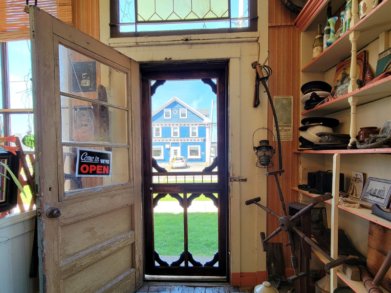 Inside the Mair Family Museum looking out the front door to the blue inn across the street