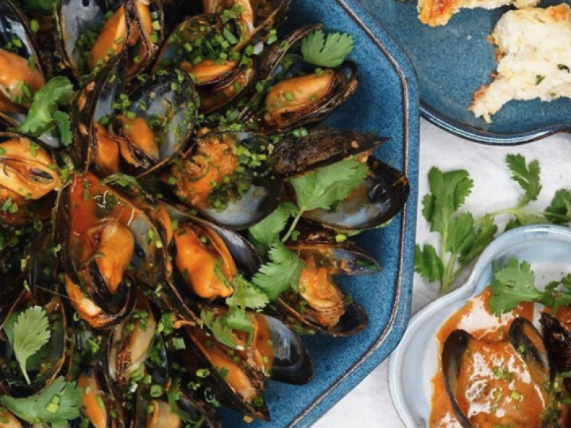 PLated maple curried mussels garnished with cilantro