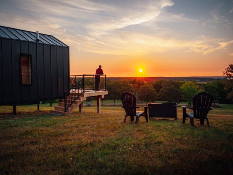 Off-grid tiny modern cabin with deck and outdoor campfire pit and chairs