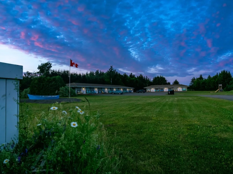The North Rustico Harbour Inn at dusk overlooking the lawn and moody sky