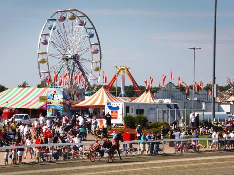 Image of Prince Edward Island's Old Home Week Festival event grounds, including harness racing, festival tents and amusement rides.