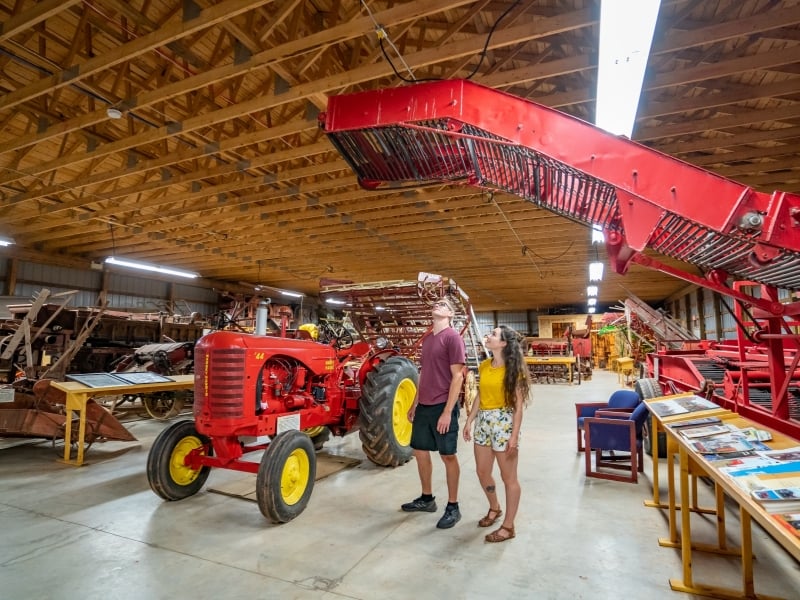 Two people tour Canadian Potato Museum machinery exhibit