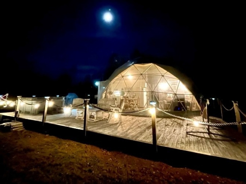 Exterior view of dome at Shoreline Retreat Ltd. at night under full moon