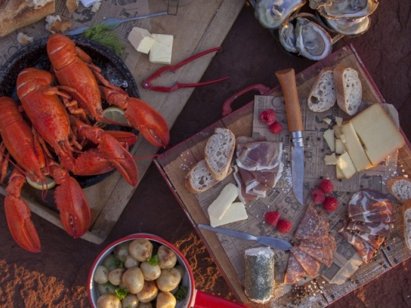 PEI beach picnic with cooked lobster, potatoes, oysters, cheese, bread and deli meat 