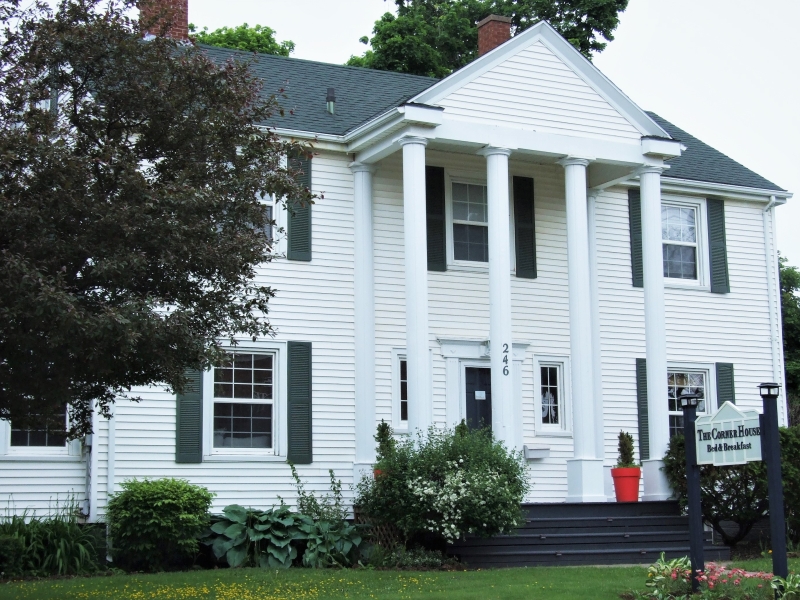 Large two-storey white home with black shutters and front columns