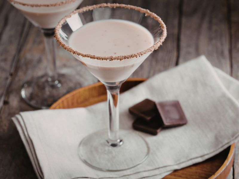 Stock image of Maple Martini in martini glass with pieces of chocolate on plate beside