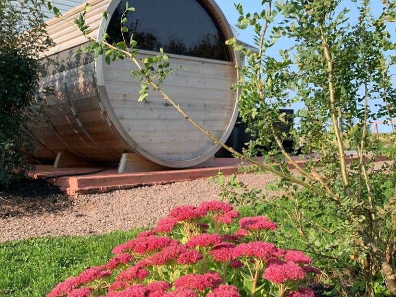 Outdoor barrell sauna with flowers in foreground at the Graham Inn, Cavendish