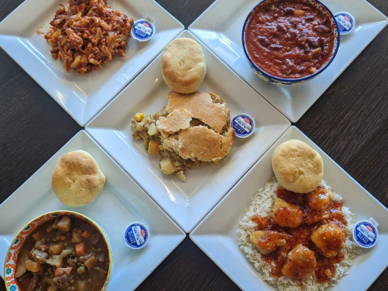 Five plates of lunch menu items displayed each with a biscuit and butter