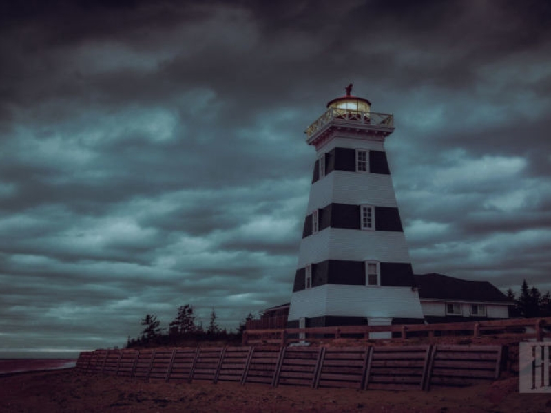 Eerie outside view of the West point Lighthouse surrounded by dark clouds