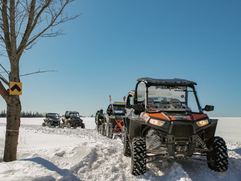 Convoy of ATVs ride winter trail