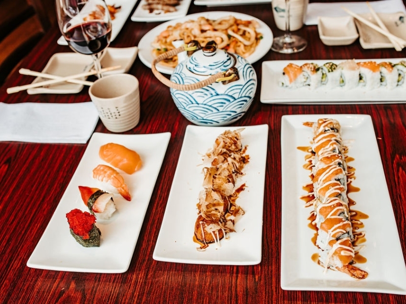 Sushi platters and pot of tea set on table at Yumi Sushi