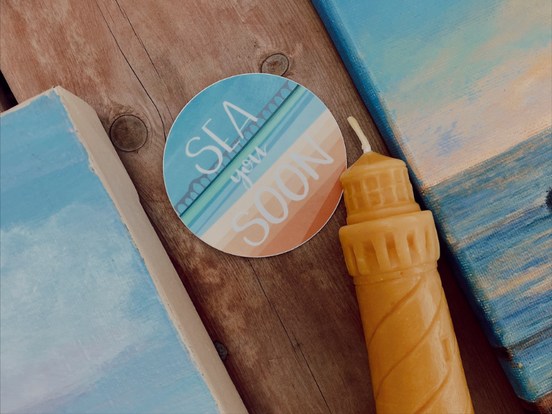 Bees wax lighthouse candle, coastal paintings and "Sea You Soon" sticker